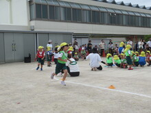 運動会でコーナーを走るこどもたちの写真