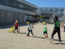屋外でサッカーをするこどもたちの写真