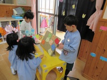 屋内で紙製の人形を使い、人形劇をするこどもたちの写真