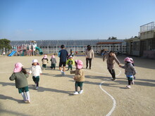 外でおにごっこをするこどもたちの写真