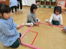 コマ回しに挑戦するこどもたちの写真