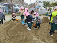 砂で山を作るこどもたちの写真