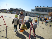 鉄棒に手足をかけるこども