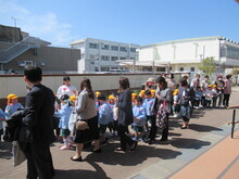 屋外で並んで保護者とともに歩いているようす