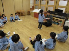 輪になって話を聞くこどもたちのようす