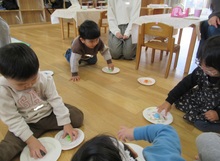 紙皿で作ったコマで遊ぶこどもたちの写真