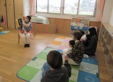 絵本の読み聞かせに聞き入るこどもたちの写真