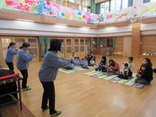 お話会で講師が手遊びを見せるようす