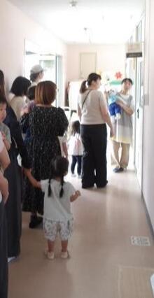 絵本のお話を熱心に聞いているこどもと保護者たちの写真