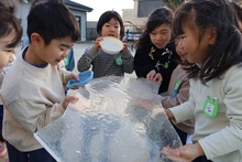 張った氷を持つこどもたち