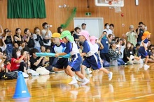 大勢の観客の前で演技をするこどもたちの写真