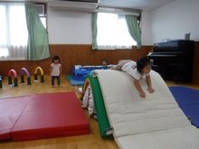 マットの上で運動するこどもの写真