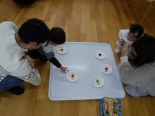 床に置いた板の上で凧やこまを作るこどもたちの写真3