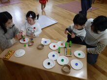 机の上で凧やこまを作るこどもたちの写真1