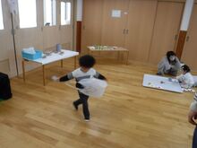 できあがった凧を持ち走っているこどもの写真1