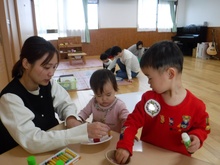 机の上で凧やこまを作るこどもたちの写真2