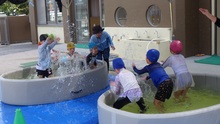 友だちと水のかけあいをしています