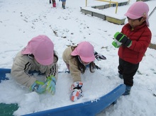 滑り台に積もった雪を集めています