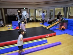 屋内の遊具で体を動かすこどもたちの写真