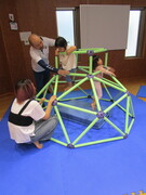 屋内の遊具に登るこどもたちの写真