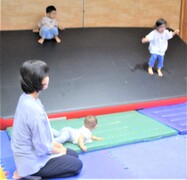 屋内でマットの上に乗るこどもの写真