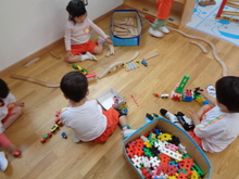 部屋の玩具の一つである木製の線路をつなげたりブロックを組み合わせたりして遊んでいます。