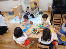 椅子に座って洗濯ばさみ遊びやひも通しを楽しんでいます。