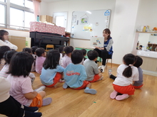 クラスのみんなで集まって紙芝居を見ながら手の洗い方を学んでいます。