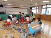 遊戯室で新聞遊びをダイナミックにしています。破ったり投げたり、お風呂にしたりしています。
