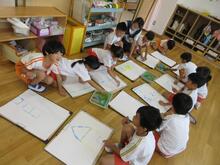 段ボールの端の並々の形を利用して、画用紙に絵具でスタンプしながら形を作っていきます。