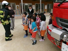 消防士さんに園児が質問しています。