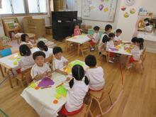 ブドウの形の画用紙にブドウの実をイメージした画用紙をのりで張り付けています。