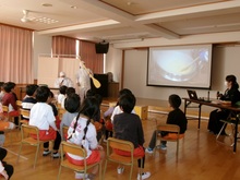 給食集会で給食がどうやって作られているか写真を見ています。