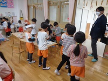 小学校の先生が5歳児の保育を見ています。