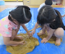 土粘土を足で踏んで、平たくしました