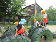 小学校運動場の大きなタイヤに乗って、心地よい風を感じています